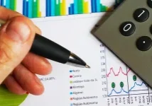 Analyzing financial charts and graphs with a calculator, highlighting tips for landlords in DFW to spot financial trouble earl